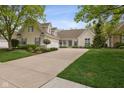Charming two-story home boasts a three-car garage, beautiful landscaping, and a welcoming front porch at 10725 Grindstone Dr, Fishers, IN 46037
