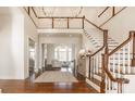 Elegant foyer with hardwood floors, staircase, chandelier, and open view to the living area at 1098 Laurelwood, Carmel, IN 46032