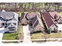 A bird's eye view of a brick home showcasing the surrounding neighborhood and lush greenery at 14365 Laura Vista Dr, Carmel, IN 46033