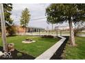 Spacious backyard featuring lush green grass, mature trees, and black mulch at 1508 N Woodridge Ave, Muncie, IN 47304