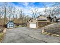 Detached garage with basketball hoop with an adjacent shed and a spacious paved driveway at 381 Redbud Pl, Greenwood, IN 46142