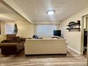 Cozy basement area perfect for relaxing, featuring a comfortable sofa and natural light from the window at 3932 Caroline Ave, Indianapolis, IN 46205