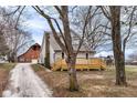 Beautiful gray home with a large wooden deck, barn, and ' play set in the spacious backyard at 435 N Chestnut St, Monrovia, IN 46157