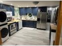 Well-lit kitchen features blue cabinets, stainless steel appliances, and butcher block countertops at 4904 Betholm Dr, Indianapolis, IN 46239