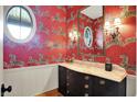 Stylish powder room features unique zebra wallpaper, vanity with marble countertop, and decorative lighting at 5120 Melbourne Pl, Zionsville, IN 46077