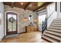 Inviting entryway with wooden floors, brick accent wall, and natural light at 5120 Melbourne Pl, Zionsville, IN 46077
