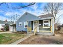 Charming blue home with a covered carport and a cozy front porch at 5350 E 20Th Pl, Indianapolis, IN 46218