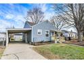 Charming blue home featuring a covered carport, a shed, and a cozy front porch at 5350 E 20Th Pl, Indianapolis, IN 46218