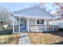 Inviting single story home showing the covered front porch and walkway on a sunny day at 553 N Traub Ave, Indianapolis, IN 46222