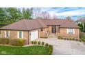 Charming brick home with a well-manicured lawn, inviting entrance, and a spacious driveway at 6043 Acorn Dr, Columbus, IN 47201