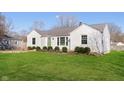 Classic single-story home with green lawn, showcasing the clean white facade and natural light from the windows at 6721 Evanston Ave, Indianapolis, IN 46220