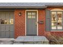 Close up of the front entrance with storm door and gray shutters at 7021 Warwick Rd, Indianapolis, IN 46220