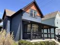 Charming two-story home with blue siding, an orange gable, black trim, and a covered front porch with modern railing at 1334 E Market St, Indianapolis, IN 46202