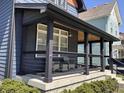 Inviting front porch features a seating area, modern railings, dark wood trim, and a wood ceiling at 1334 E Market St, Indianapolis, IN 46202