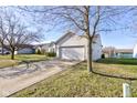 This home boasts a well-manicured lawn, a long driveway, and an attached two-car garage for added convenience at 1360 Evergreen Dr, Greenfield, IN 46140