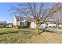 This home features a charming exterior with well-maintained landscaping, a two-car garage, and mature trees at 1360 Evergreen Dr, Greenfield, IN 46140