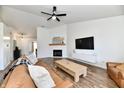 Spacious living room featuring wood floors, a fireplace, a leather sofa, and modern decor at 14938 Silver Thorne Way, Carmel, IN 46033