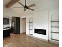 Open-concept living area featuring vaulted ceilings, beams, a fireplace, and modern finishes at 1716 E Kelly St, Indianapolis, IN 46203