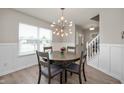 Bright dining room featuring wood floors, modern lighting, and window overlooking the neighborhood at 17918 Lucas Cir, Westfield, IN 46074