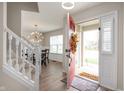 Inviting entryway with a view of the staircase and dining area featuring modern light fixture at 17918 Lucas Cir, Westfield, IN 46074