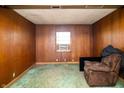 Inviting living room with wood paneling, window AC, and comfortable armchair at 1821 E Stop 10 Rd, Indianapolis, IN 46227