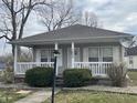 Charming home featuring a cozy front porch, gray siding, and a well-maintained landscaped yard at 1835 Carpenter Cir, Indianapolis, IN 46203