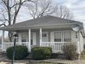 Charming home featuring a cozy front porch, gray siding, and a well-maintained landscaped yard at 1835 Carpenter Cir, Indianapolis, IN 46203