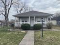 Cozy home featuring a classic front porch, neutral siding, and a simple landscaped front yard at 1835 Carpenter Cir, Indianapolis, IN 46203
