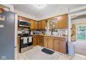 Traditional kitchen with wood cabinets, stainless steel appliances, tile backsplash, and neutral countertops at 1906 E Markwood Ave, Indianapolis, IN 46227