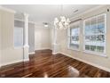 Elegant dining room featuring hardwood floors, a stylish chandelier, and bright natural light from large windows at 1975 Westminster Pl, Columbus, IN 47201