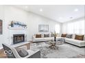 Bright living room with fireplace, vaulted ceiling, large windows, and comfortable seating at 2425 Silver E Ct, Carmel, IN 46033