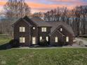 Two-story brick home exterior featuring warm lighting and a sunset backdrop at 2525 Sunderland Dr, Martinsville, IN 46151