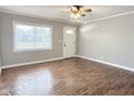 Bright living room features wood-look flooring, fresh paint, a front-facing window, and ceiling fan with light fixture at 2638 Calbert Dr, Indianapolis, IN 46219