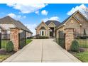 Elegant brick home featuring a gated entrance and a long driveway leading to the front door at 4703 River Ridge Dr, Indianapolis, IN 46240