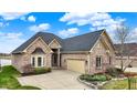 Beautiful brick home with an attached two-car garage and manicured landscaping at 4703 River Ridge Dr, Indianapolis, IN 46240