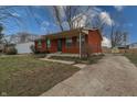Quaint brick home featuring a covered front porch, green shutters, and a spacious driveway at 4812 Eastgate Dr, Columbus, IN 47203