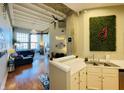 Open-concept kitchen with stainless steel sink, white cabinets and view of an expansive living space at 611 N Park Ave # 405, Indianapolis, IN 46204