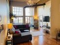 Bright living room with high ceilings, expansive windows, and modern chandelier at 611 N Park Ave # 405, Indianapolis, IN 46204