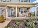 Welcoming front porch with cozy seating, beautiful landscaping, and charming details that enhance curb appeal at 6746 Wilmot Ln, Avon, IN 46123