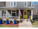 Inviting front porch with railing, planters, and an American flag displayed at 774 Woodruff Pl E Dr, Indianapolis, IN 46201