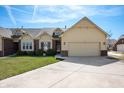 A well-maintained townhome with an attached garage and neat landscaping, complete with a long driveway at 946 Peppermill Run, Greenwood, IN 46143