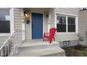 Close up of a charming front porch featuring a bright blue door, a red chair, and neutral-colored siding at 952 E 34Th St, Indianapolis, IN 46205