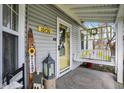 Charming front porch with a swing, 'Welcome' sign, and the house number displayed above the glass front door at 10730 N Park Ave, Carmel, IN 46280