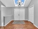 Bright foyer featuring wood floors, a skylight, and white double doors, offering a grand entrance to the home at 108 Parkridge Dr, Danville, IN 46122
