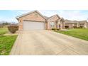 Charming brick home featuring a two-car garage and beautifully landscaped front yard at 1120 Constitution Dr, Edinburgh, IN 46124