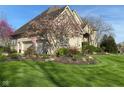 Charming home with a two-car garage, lush landscaping, and an American flag at 11967 Windpointe Pass, Carmel, IN 46033
