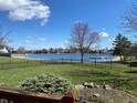 Scenic lake view from the backyard featuring a well-maintained lawn and wrought iron fence at 11967 Windpointe Pass, Carmel, IN 46033