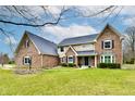 Beautiful two-story brick home on a lush lot with a covered front entry and manicured landscaping at 12917 Brighton Ln, Carmel, IN 46032