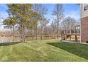 Expansive backyard with lush green grass leading to a serene pond and a spacious deck at 1527 Canyon Oak Ln, Columbus, IN 47201