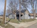 A quaint house featuring a classic gray siding and a dark roof, nestled between mature trees on a corner lot at 1546 S New Jersey St, Indianapolis, IN 46225